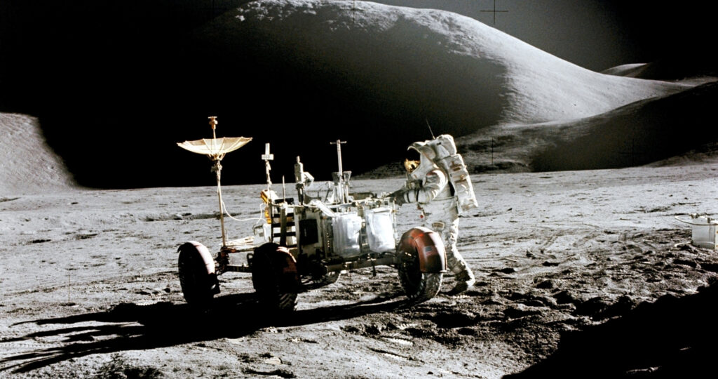 Der US-amerikanische Astronaut Jim Irwin mit demApollo-15-Mondauto auf dem Mond 1971.